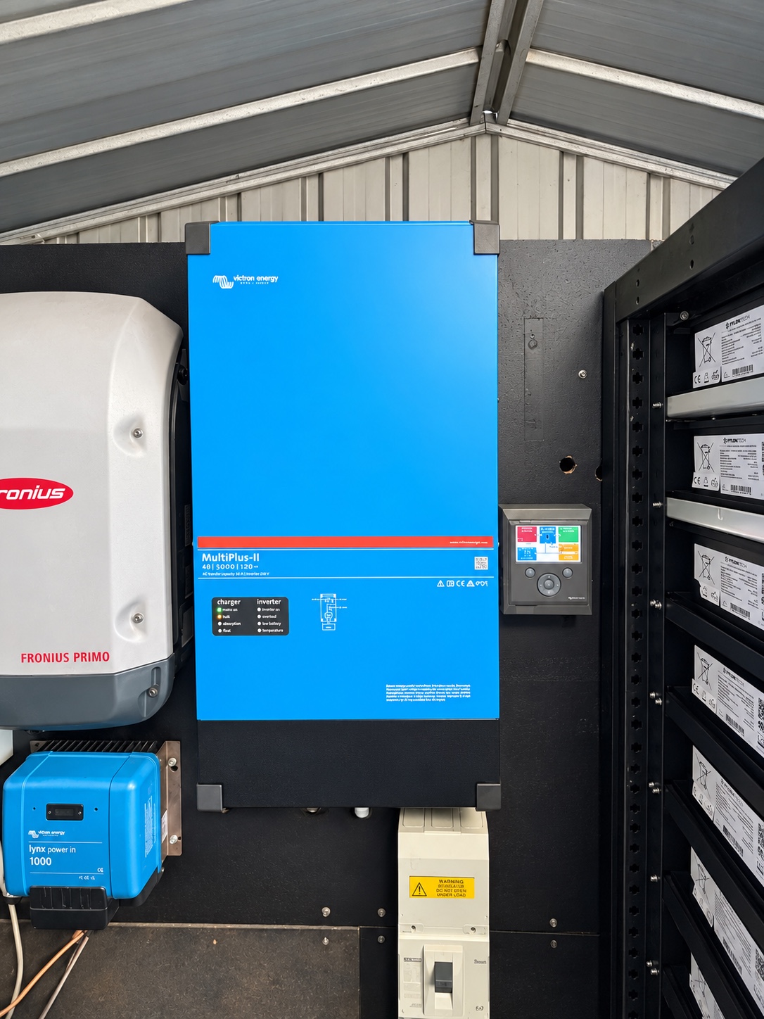 Victron and Fronius inverter equipment beside the battery rack